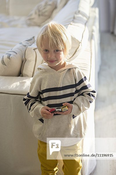Porträt eines Jungen mit Spielzeugautos
