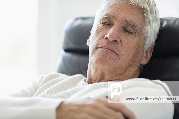 Close-up of a senior man sleeping on chair