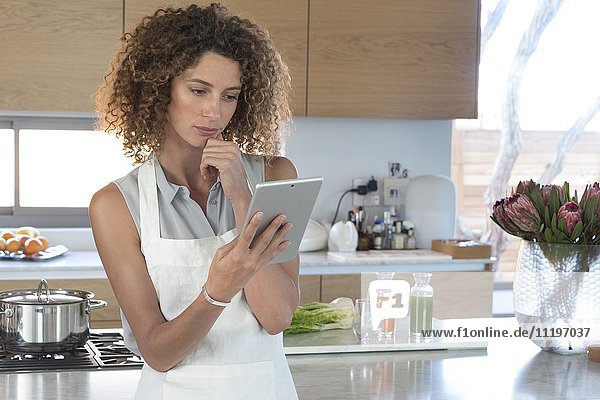 Young woman using a digital tablet in the kitchen
