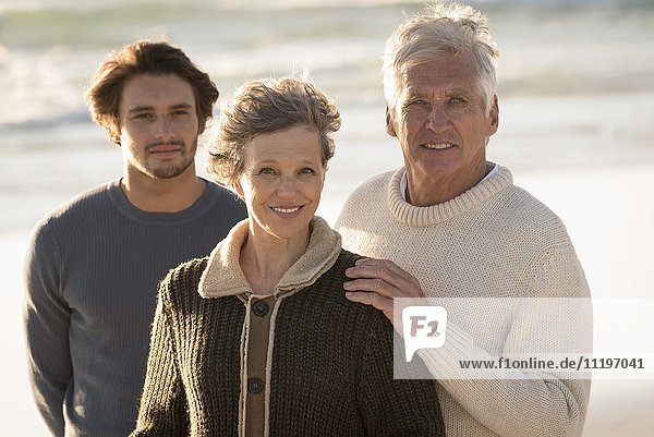 Portrait of happy family standing on the beach