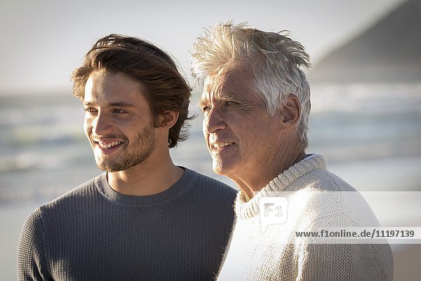 Glücklicher Vater und Sohn stehen am Strand
