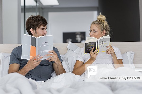 Happy young couple reading books