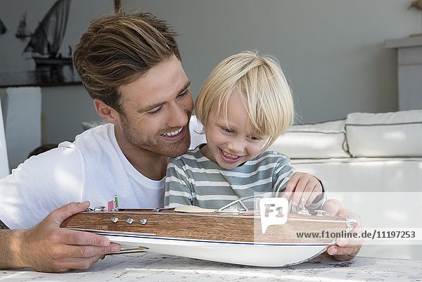 Glücklicher Vater und Sohn mit einem Modellboot