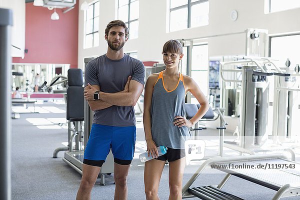 Junges Paar steht im Fitnessstudio