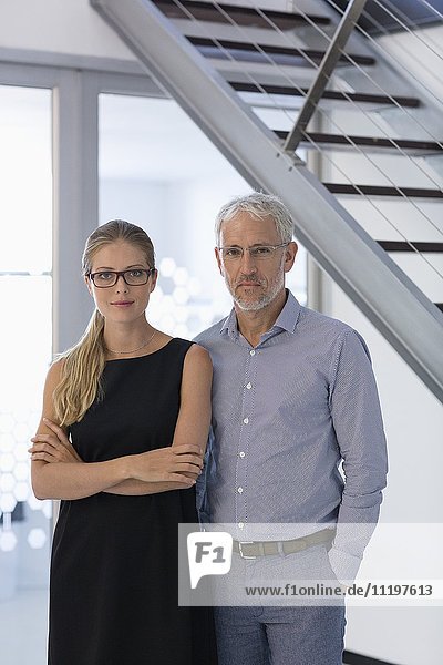 Portrait of happy business coworkers standing together in office