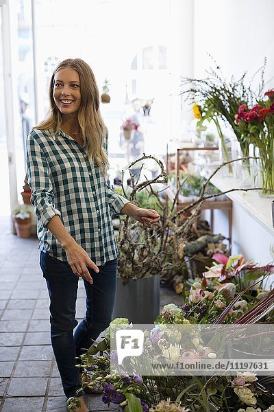 Happy woman standing at flower shop