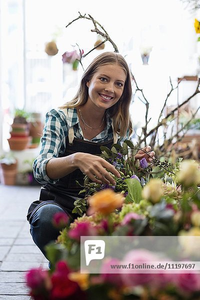 Porträt einer Floristin lächelnd in ihrem Geschäft