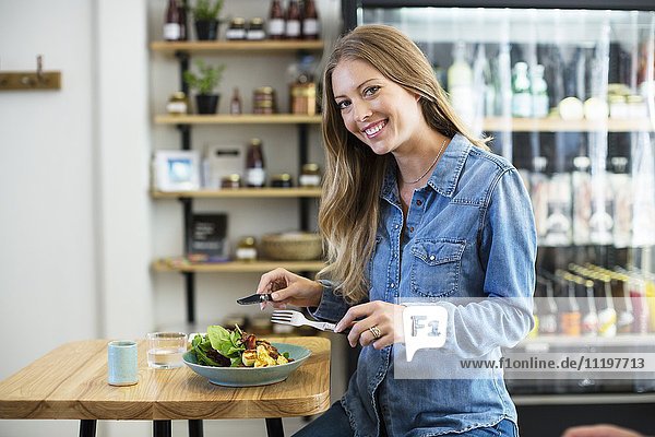 Porträt einer glücklichen Frau beim Mittagessen in einem Restaurant