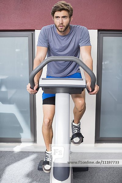 Man exercising on a bicycle in a gym
