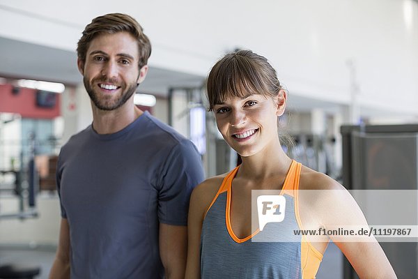 Happy young couple standing in a gym