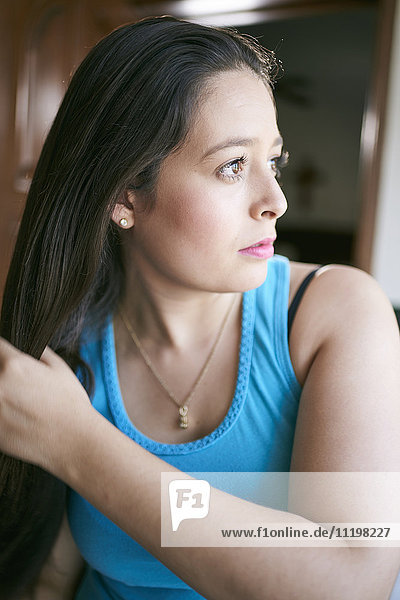Hispanic woman brushing hair