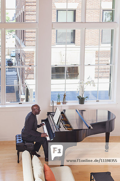 Mann spielt Klavier in der Nähe des Fensters