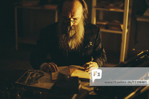 Kaukasischer Mann mit Bart  der ein Buch liest