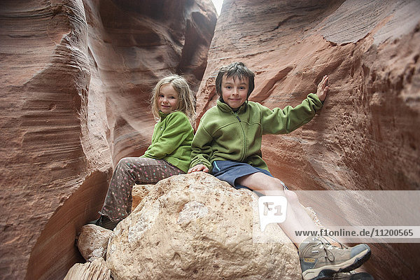 Kinder sitzen auf einer Felsformation in Utah  USA