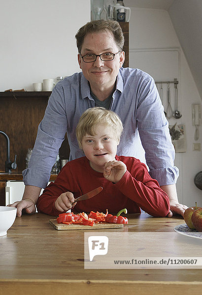 Portrait von Vater und Junge bei Tisch in der Küche