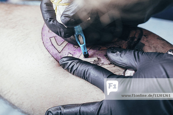 Künstler-Tätowierungsdesign auf menschlicher Haut im Atelier