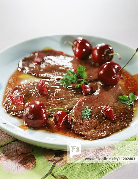 Thinly sliced duck with cherries