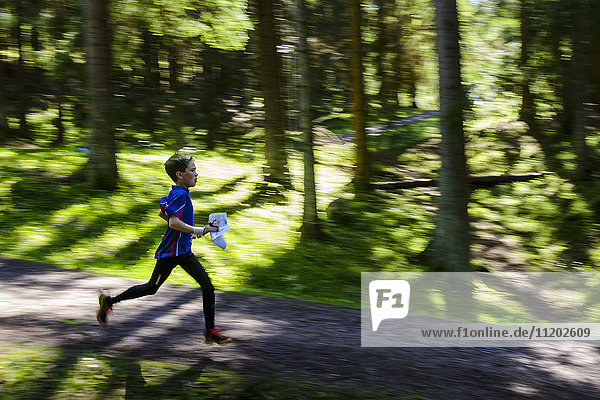 Boy running through forest