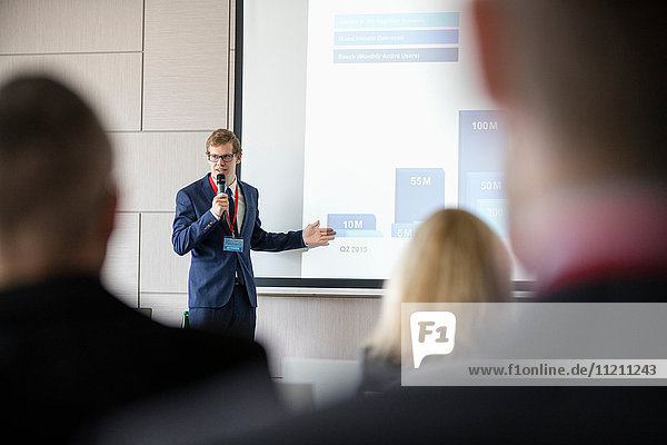 Businessman giving presentation in seminar hall at convention center