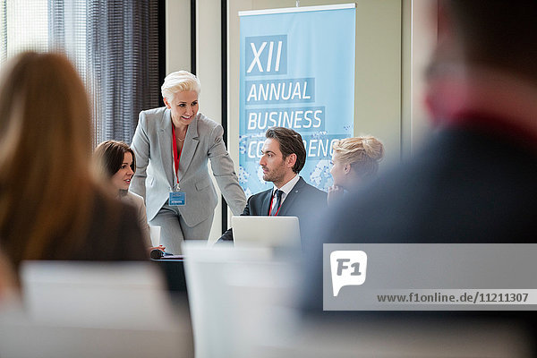 Businesswoman talking to colleagues during seminar