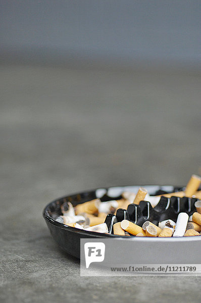 Full ashtray of cigarettes on table  close-up