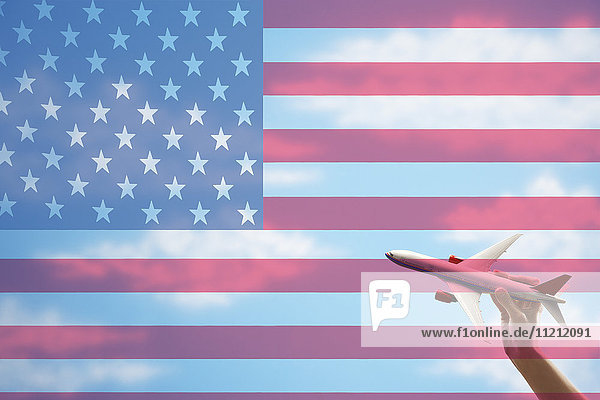 Spielzeugflugzeug fliegt vor US-Flagge