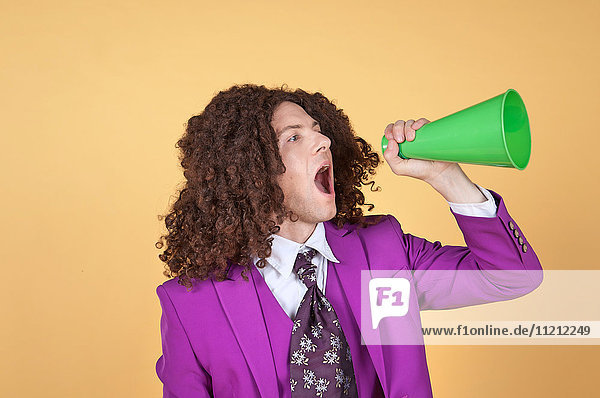 Caucasian man with afro wearing Purple Suit shouting from a cone