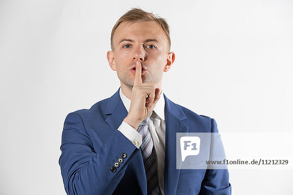 Businessman with finger over lips