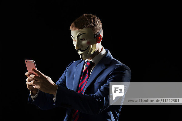 Geschäftsmann unter der Maske  der sich als Anonymous verkleidet und andeutet  dass er ein Hacker oder Anarchist ist