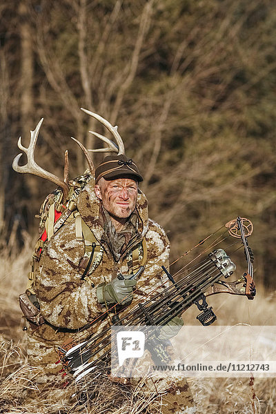 Bowhunter In Camo Clothing hunting Whitetail Deer