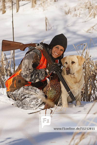 Female Pheasant Hunter In Winter With Yellow Lab
