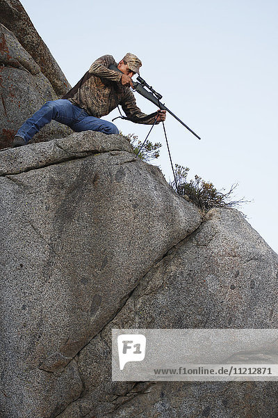 Western Big Game Rifle Hunter Using Bipod Shooting Stick In Western Usa