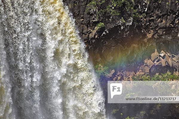 Wasser  das über eine Klippe fließt  mit einem Regenbogen im Nebel; Hawaii  Vereinigte Staaten von Amerika'.