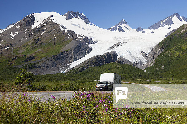 A pickup pulls a camp trailer down the Richardson Hwy with Worthington Glacier showing in background  Southcentral Alaska  USA