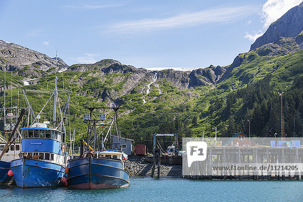 Fishing Boats docked at the Passage Canal Harbor in Prince William Sound  clear Sunny skies overhead  Whittier  South Central Alaska  USA  Summer