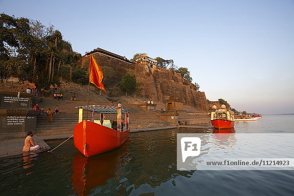Ahilya Fort and bathing ghats on the Namada River with colourful boats