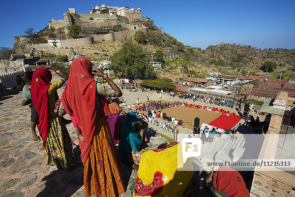 Frauen in farbenfroher traditioneller Rajasthani-Tracht vor einem verlassenen Rajput-Fort auf einem Hügel