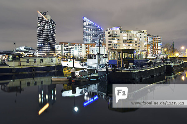 Spiegelungen im Wasser bei Nacht in den Docklands von London; London  England'.