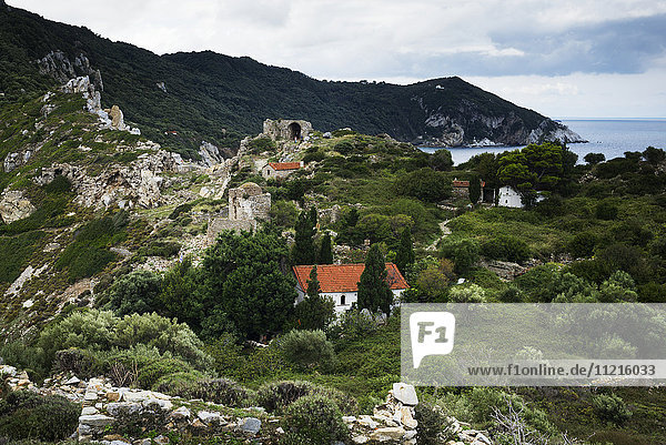 'Houses on a rugged landscape on a greek island along the Aegean sea; Skiathos  Greece'