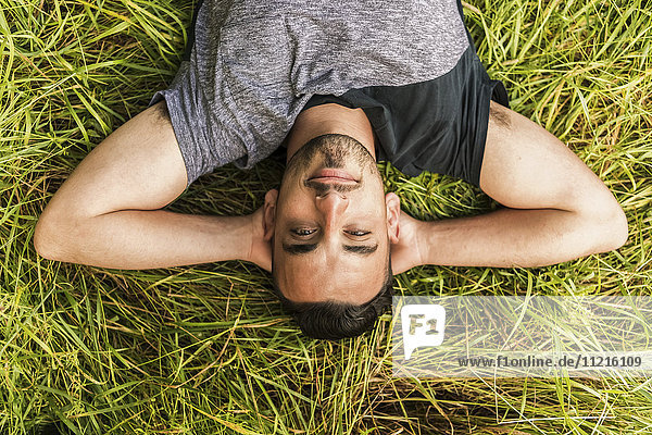 'Close up of a man laying on the grass with his hands behind his head; Reigate  England'