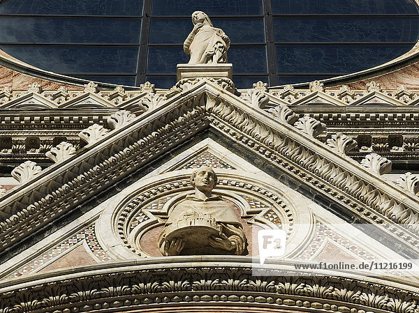 Blick von unten auf die verzierte Fassade des Doms von Siena; Siena  Italien'.