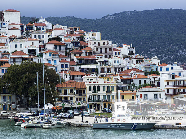 Houses on the hillside and boats in the harbour on a greek island; Skopelos Town  Skiathos  Greece