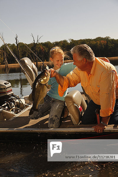 Grandfather And Grandson Fishing On Lake