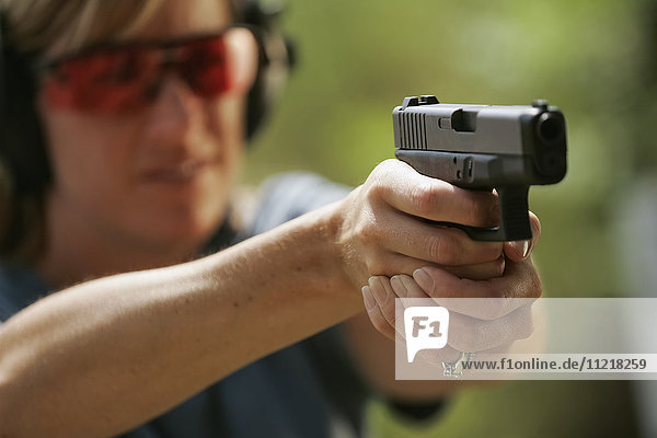 Frau zielt auf Handfeuerwaffe auf Schießstand