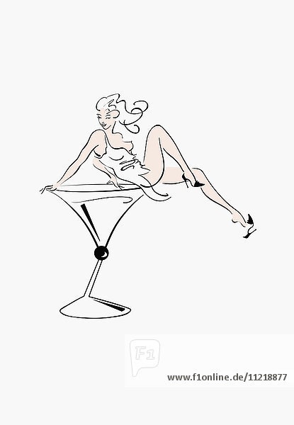 Sexy Frau sitzt in übergroßem Cocktailglas