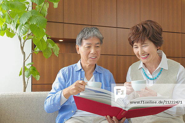 Modisches japanisches Seniorenpaar auf Sofa
