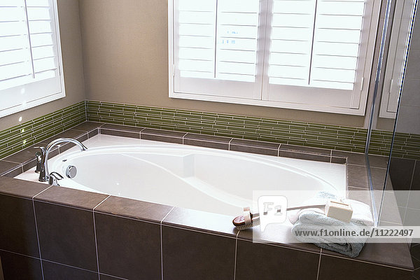 Brown tile surrounding traditional bathtub  Tustin  California  USA