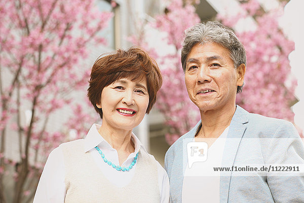 Fashionable Japanese senior couple and cherry blossoms downtown Tokyo