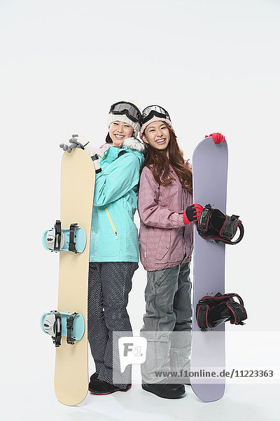 Junge japanische Frauen in Snowboardkleidung auf weißem Hintergrund