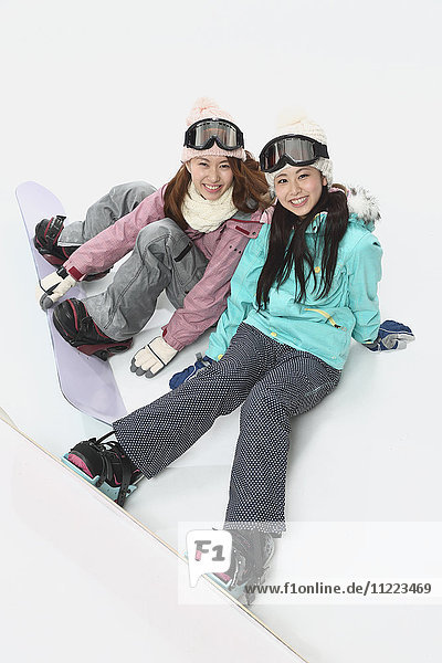 Young Japanese women wearing snowboard wear on white background